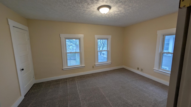 carpeted spare room featuring a textured ceiling