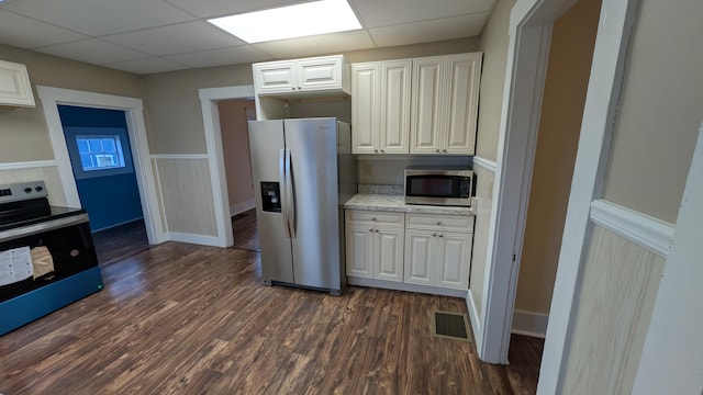 kitchen with white cabinetry, appliances with stainless steel finishes, dark hardwood / wood-style floors, and light stone countertops