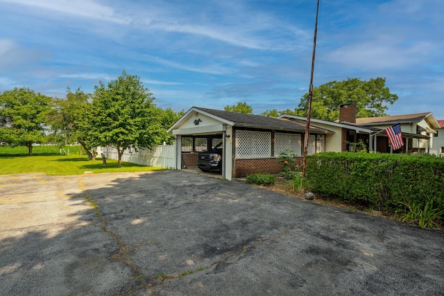 302 N W St, Arcanum, OH 45304 - view of home's exterior with a chimney, asphalt driveway, and a carport