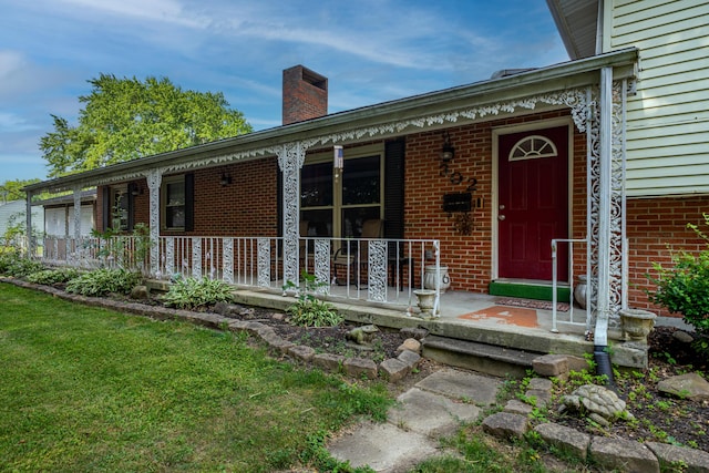 302 N W St, Arcanum, OH 45304 - doorway to property with covered porch, brick siding, a chimney, and a yard