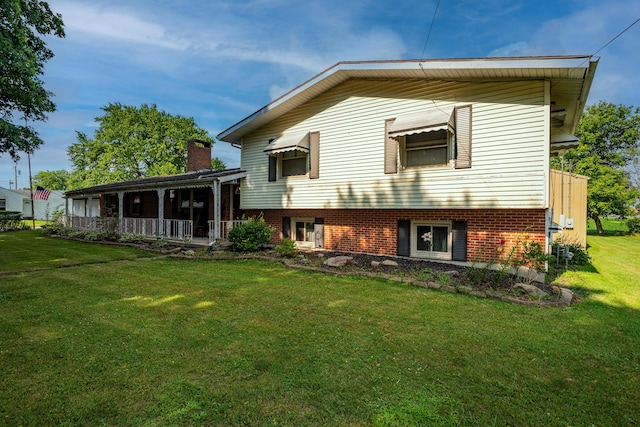 302 N W St, Arcanum, OH 45304 - back of house with a lawn, a chimney, and covered porch