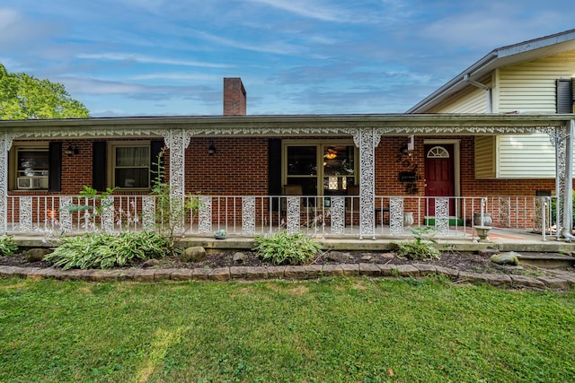 302 N W St, Arcanum, OH 45304 - view of front of house featuring covered porch, brick siding, a chimney, and a front yard