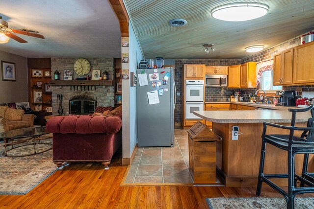 302 N W St, Arcanum, OH 45304 - kitchen with appliances with stainless steel finishes, a ceiling fan, open floor plan, a peninsula, and light countertops