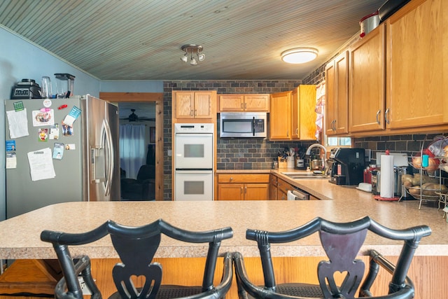 302 N W St, Arcanum, OH 45304 - kitchen featuring appliances with stainless steel finishes, light countertops, backsplash, a peninsula, and a breakfast bar area