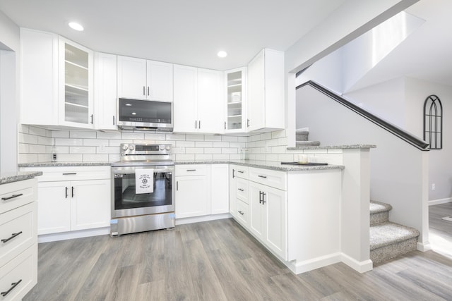 11531 Circle Dr, Lakeview, OH 43331 - kitchen featuring appliances with stainless steel finishes, light wood-style floors, light stone counters, decorative backsplash, and recessed lighting