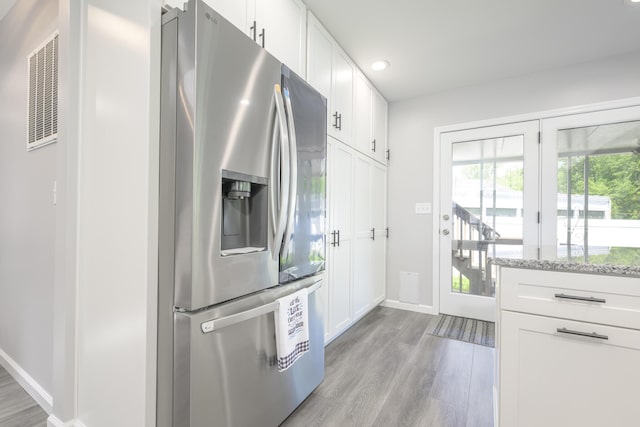 11531 Circle Dr, Lakeview, OH 43331 - kitchen with stainless steel fridge with ice dispenser, light wood-style flooring, white cabinets, light stone countertops, and recessed lighting