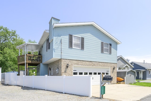 11531 Circle Dr, Lakeview, OH 43331 - view of front facade with brick siding, a garage, driveway, a storage unit, and a deck