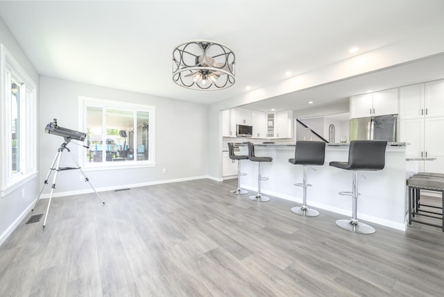 11531 Circle Dr, Lakeview, OH 43331 - kitchen with a breakfast bar, stainless steel appliances, white cabinets, a chandelier, and recessed lighting