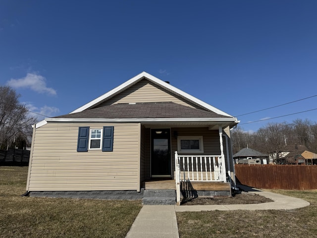 bungalow-style house featuring a porch, a front lawn, and fence