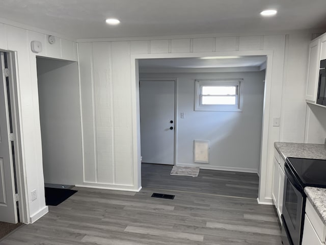 kitchen featuring recessed lighting, electric range, wood finished floors, visible vents, and white cabinetry