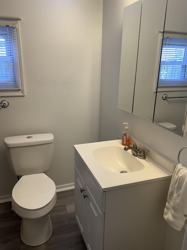 bathroom featuring vanity, wood finished floors, toilet, and baseboards