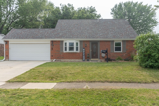 view of front of property with a front yard, brick siding, driveway, and an attached garage