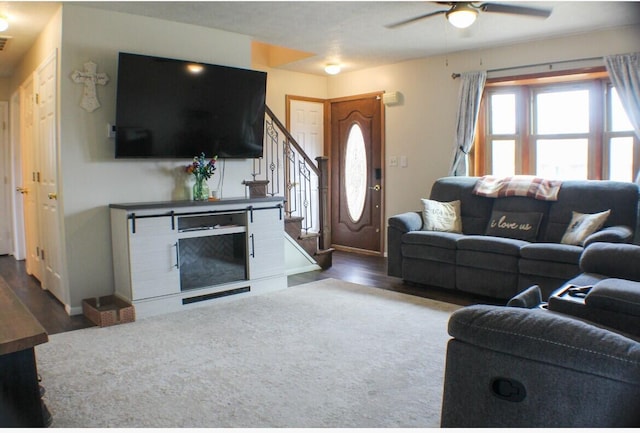 living area with ceiling fan, stairway, wood finished floors, and baseboards