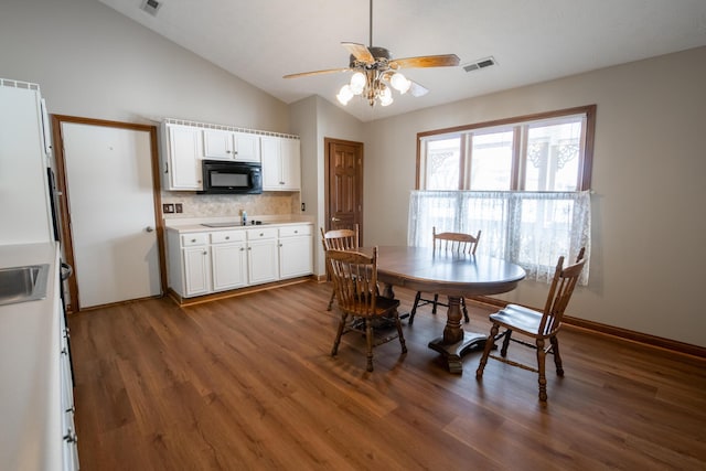 dining area with sink, lofted ceiling, dark hardwood / wood-style floors, and ceiling fan