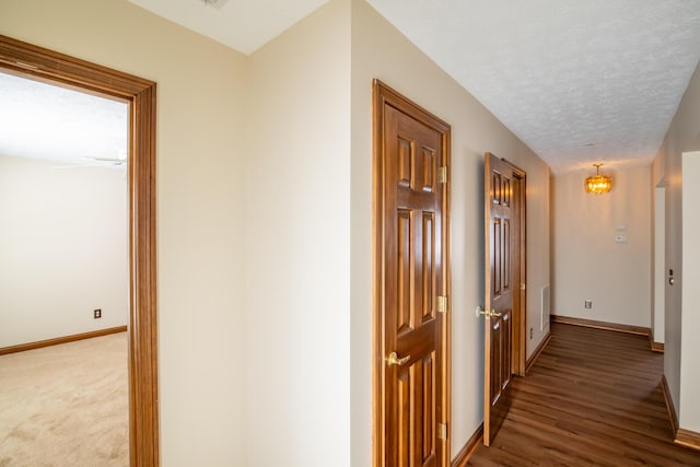 hall featuring dark hardwood / wood-style flooring and a textured ceiling