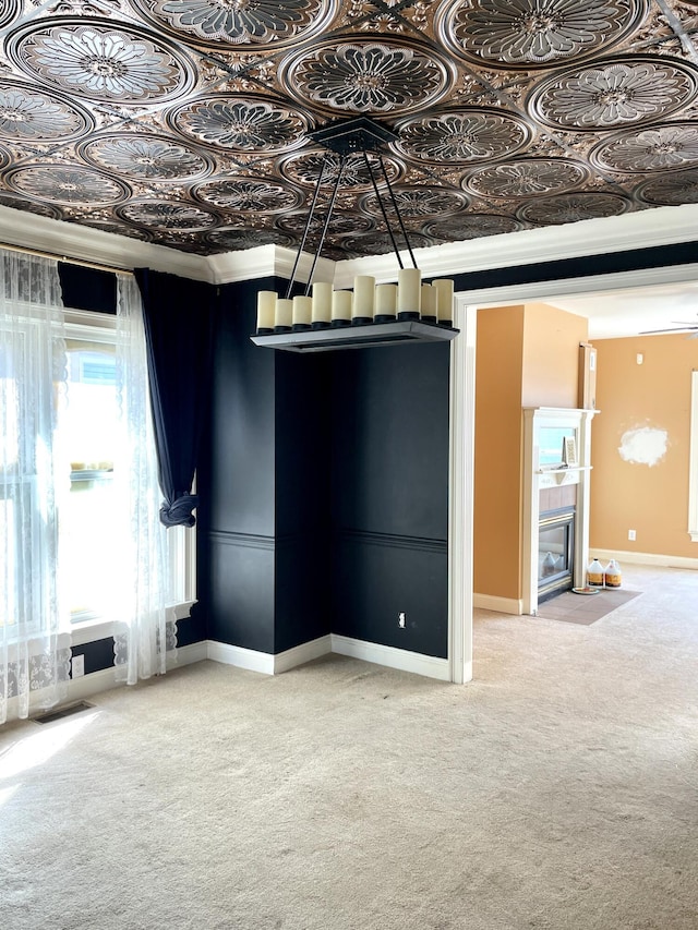 below grade area featuring baseboards, an ornate ceiling, carpet flooring, and crown molding