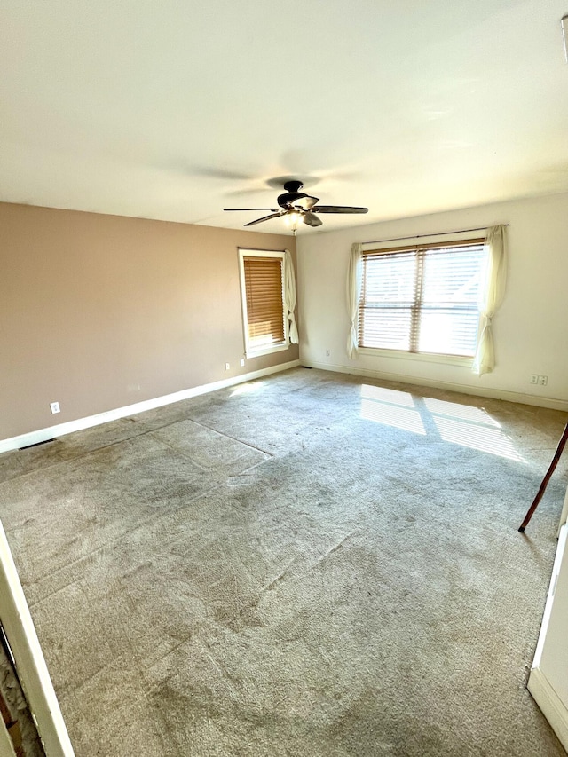 carpeted empty room with baseboards and ceiling fan