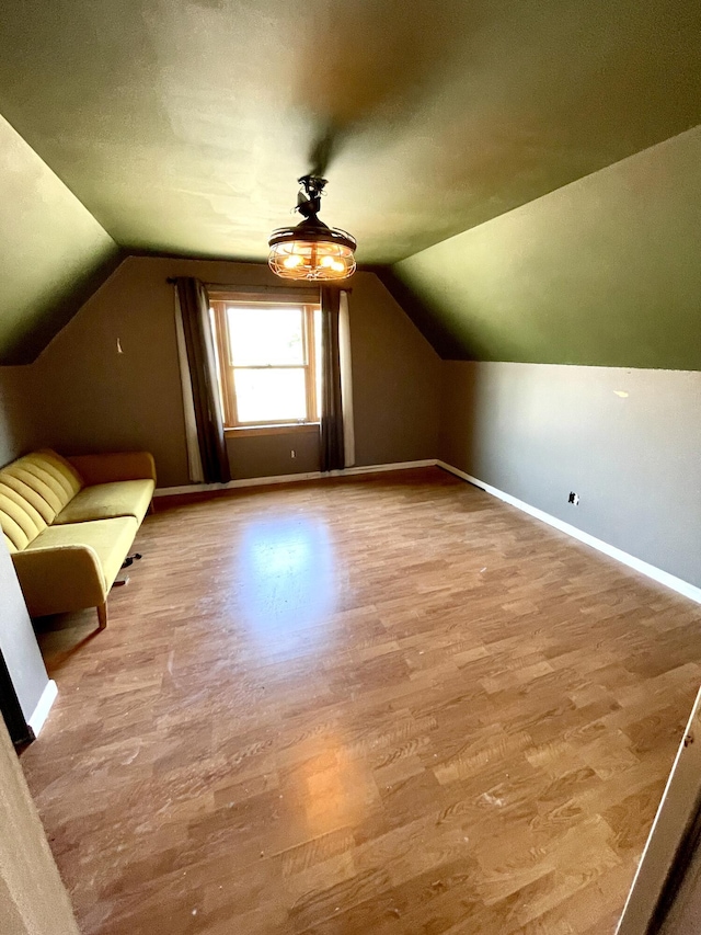 additional living space featuring a ceiling fan, vaulted ceiling, wood finished floors, and baseboards