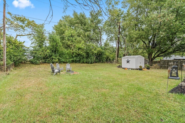 view of yard featuring a fire pit and a storage unit