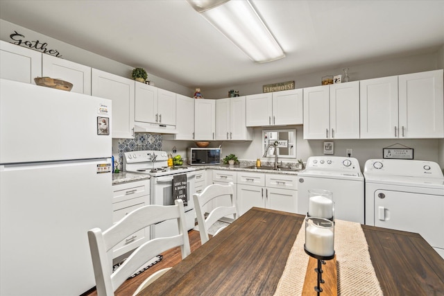 kitchen featuring white cabinetry, independent washer and dryer, sink, and white appliances