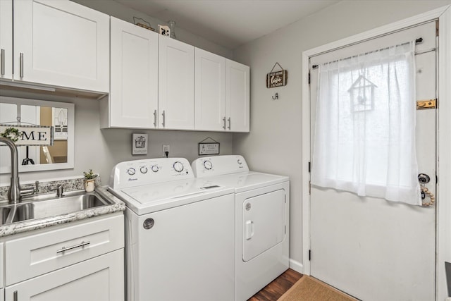 laundry area with dark hardwood / wood-style flooring, sink, washer and clothes dryer, and cabinets