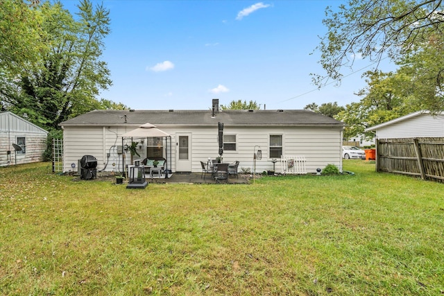 rear view of property featuring a gazebo, a lawn, and a patio area