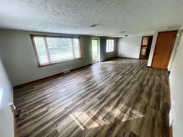 unfurnished room featuring dark wood-type flooring and a textured ceiling