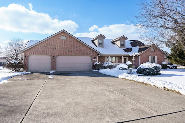 cape cod house with brick siding, an attached garage, and concrete driveway