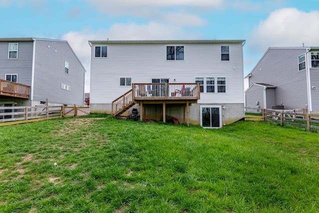 back of house with a lawn, a deck, and a fenced backyard