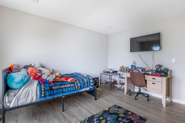 bedroom with wood finished floors and baseboards