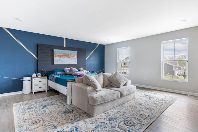 bedroom featuring baseboards, visible vents, and wood finished floors