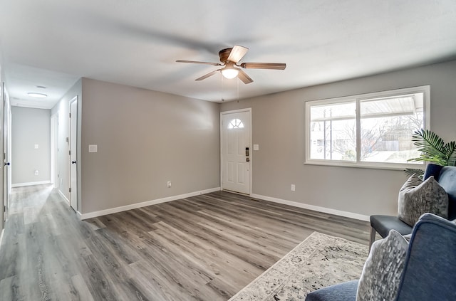 entryway featuring ceiling fan, baseboards, and wood finished floors