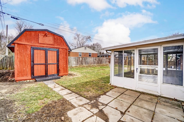 view of shed with a sunroom and a fenced backyard