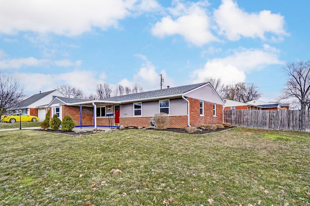 view of front of home with a front yard, fence, and brick siding