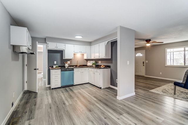 kitchen featuring dishwasher, dark countertops, open floor plan, light wood-style floors, and white cabinetry