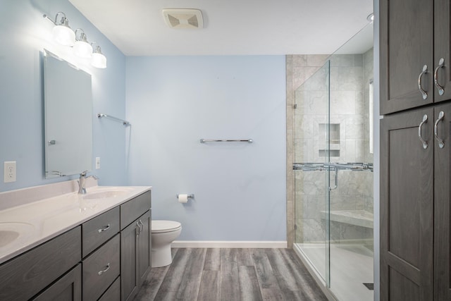 bathroom with walk in shower, vanity, toilet, and hardwood / wood-style floors