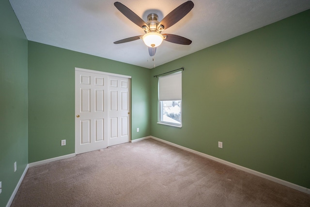 unfurnished bedroom with ceiling fan, carpet floors, and a closet