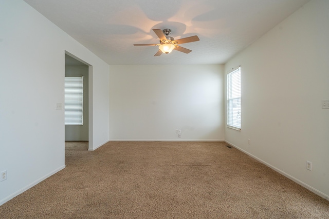 carpeted spare room featuring ceiling fan