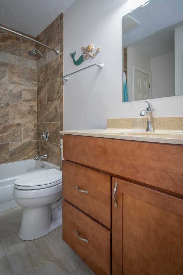 full bathroom featuring vanity, tile patterned flooring, toilet, and tiled shower / bath