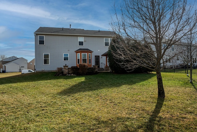 rear view of house featuring a yard