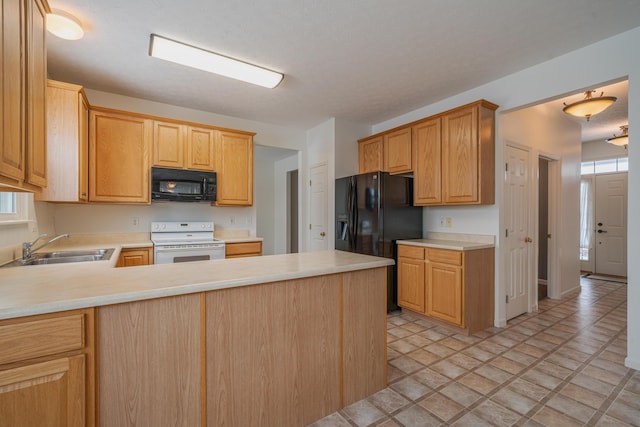 kitchen featuring a healthy amount of sunlight, kitchen peninsula, sink, and black appliances