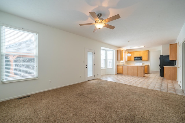 unfurnished living room featuring light carpet and ceiling fan