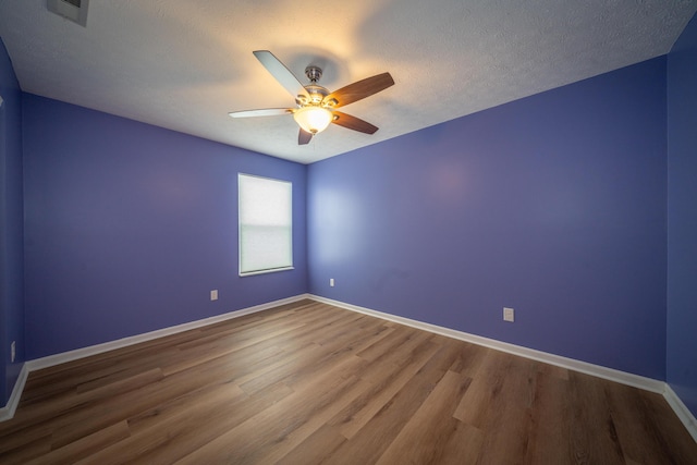 spare room featuring ceiling fan, hardwood / wood-style floors, and a textured ceiling