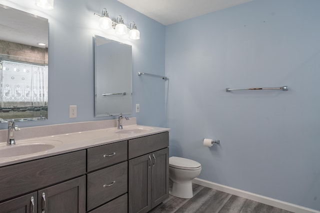 bathroom with vanity, a shower, hardwood / wood-style floors, and toilet