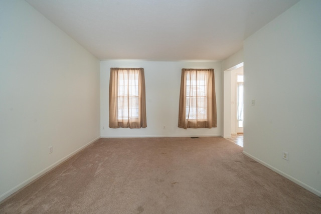 spare room featuring light colored carpet