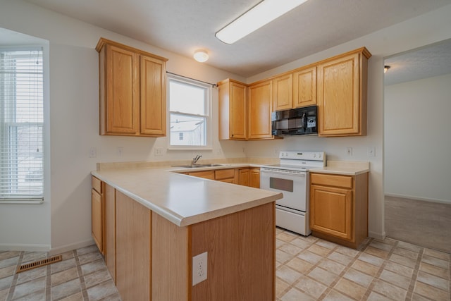 kitchen featuring sink, white electric range oven, light brown cabinetry, and kitchen peninsula