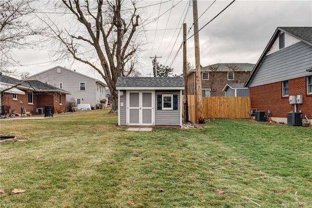 view of yard with an outbuilding, cooling unit, fence, and a shed