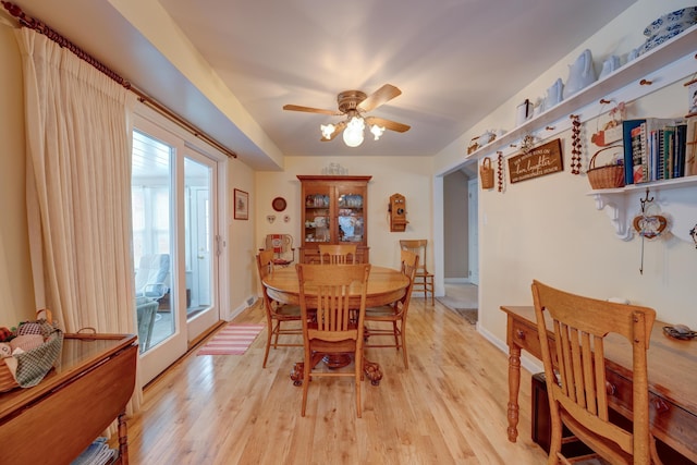 dining space with baseboards, a ceiling fan, and light wood finished floors