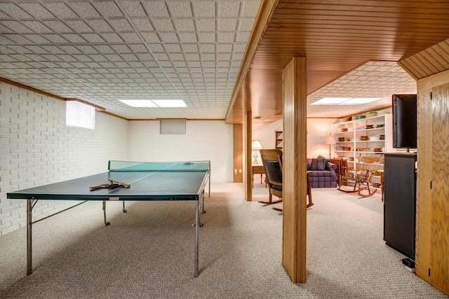 rec room with carpet flooring, brick wall, and crown molding