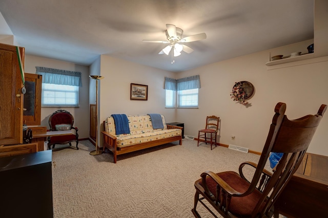 interior space with visible vents, light colored carpet, baseboards, and ceiling fan